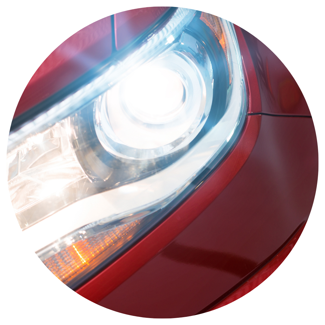 red car with headlights on 