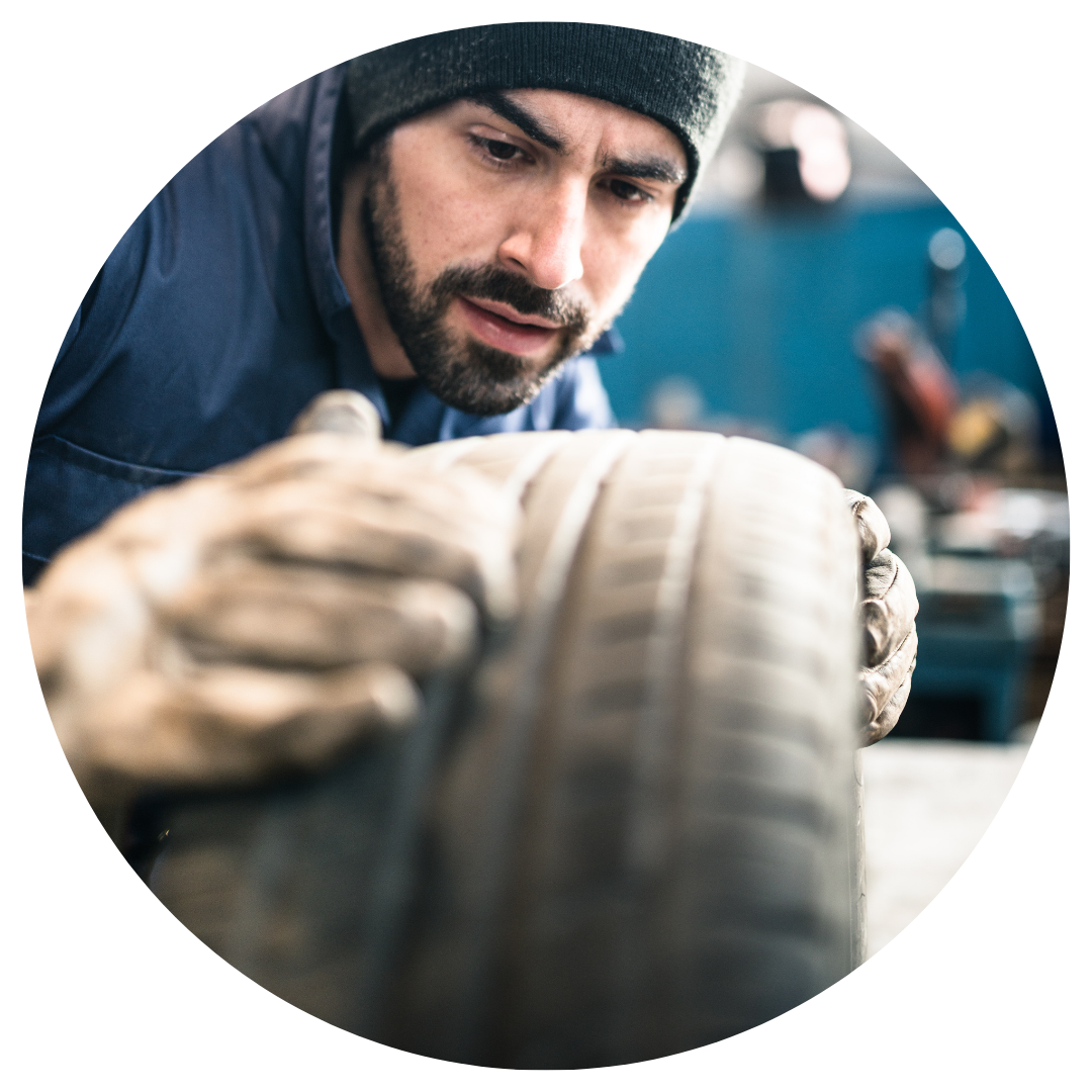mechanic looking at a tire 